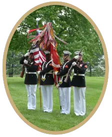 four marines in dress blues holding the us flag in arlington cemetary for lz loon rememberance